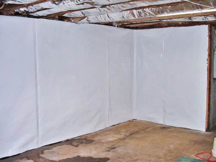 Basement with white waterproofing sheets on the walls.