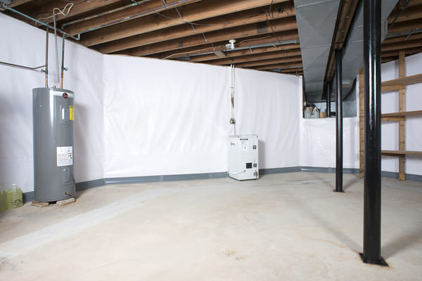 Clean basement with exposed ceiling, white plastic walls, water heater, and shelving.