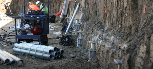 Workers at a construction site installing foundation support systems.