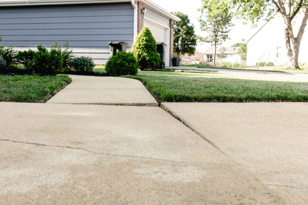 a sidewalk and grass in front of a house